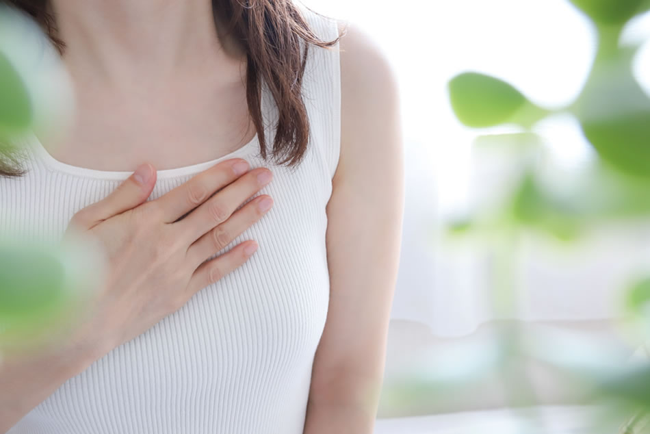 胸に手を当てる女性の様子